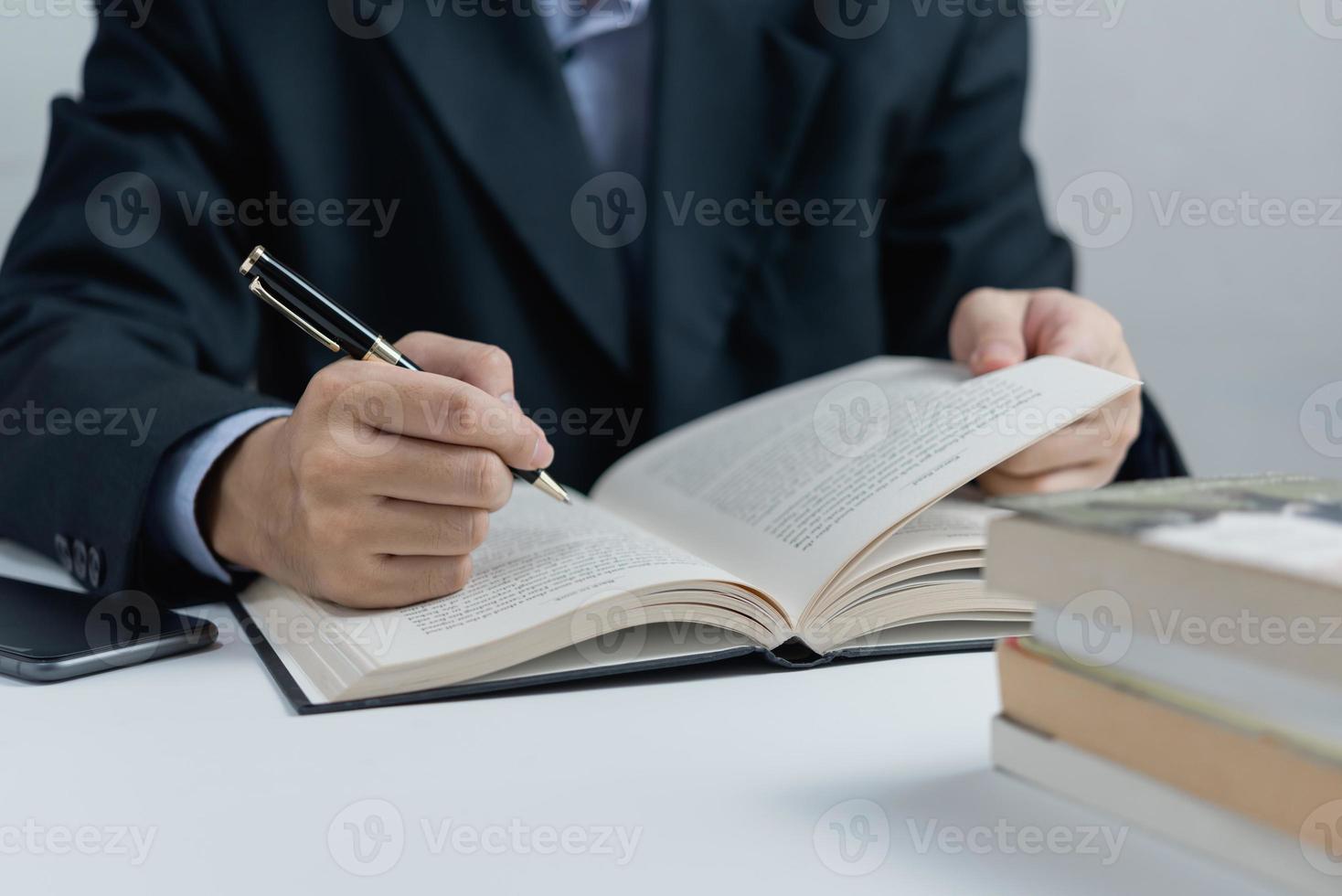 Businessperson reading and writing on book.education studying knowledge development and cognition learning concept. photo