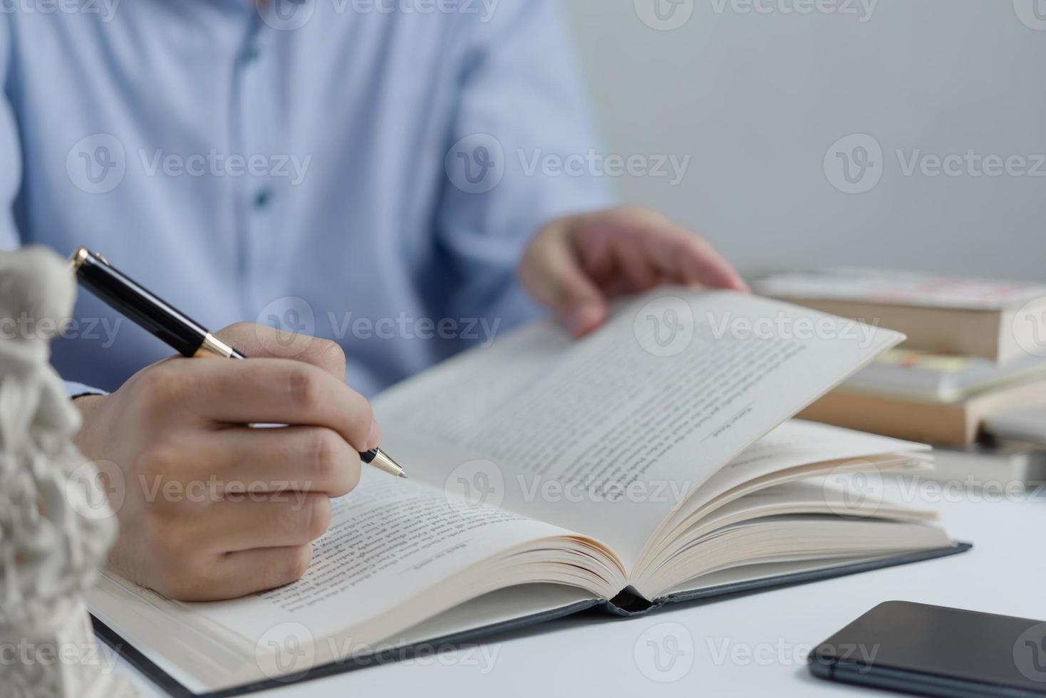 Businessperson reading and writing on book.education studying knowledge development and cognition learning concept. photo