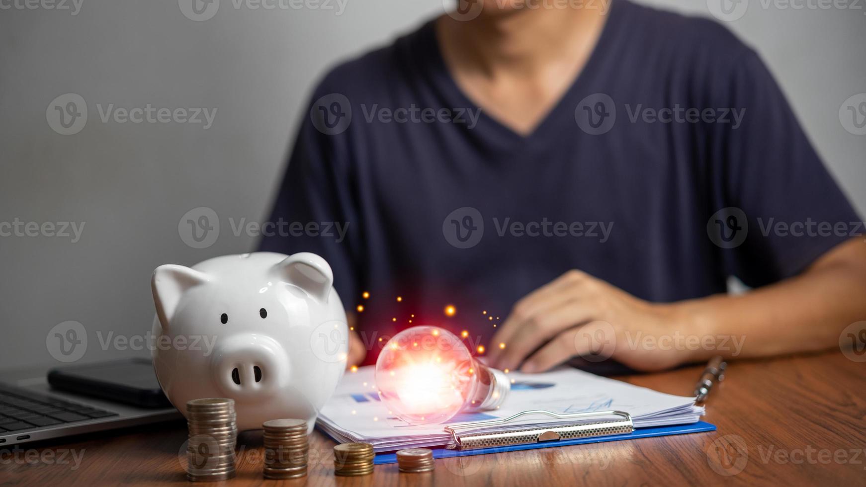 Business light bulb and piggy bank on document graph the table for energy saving and money concept banking on the desk. photo
