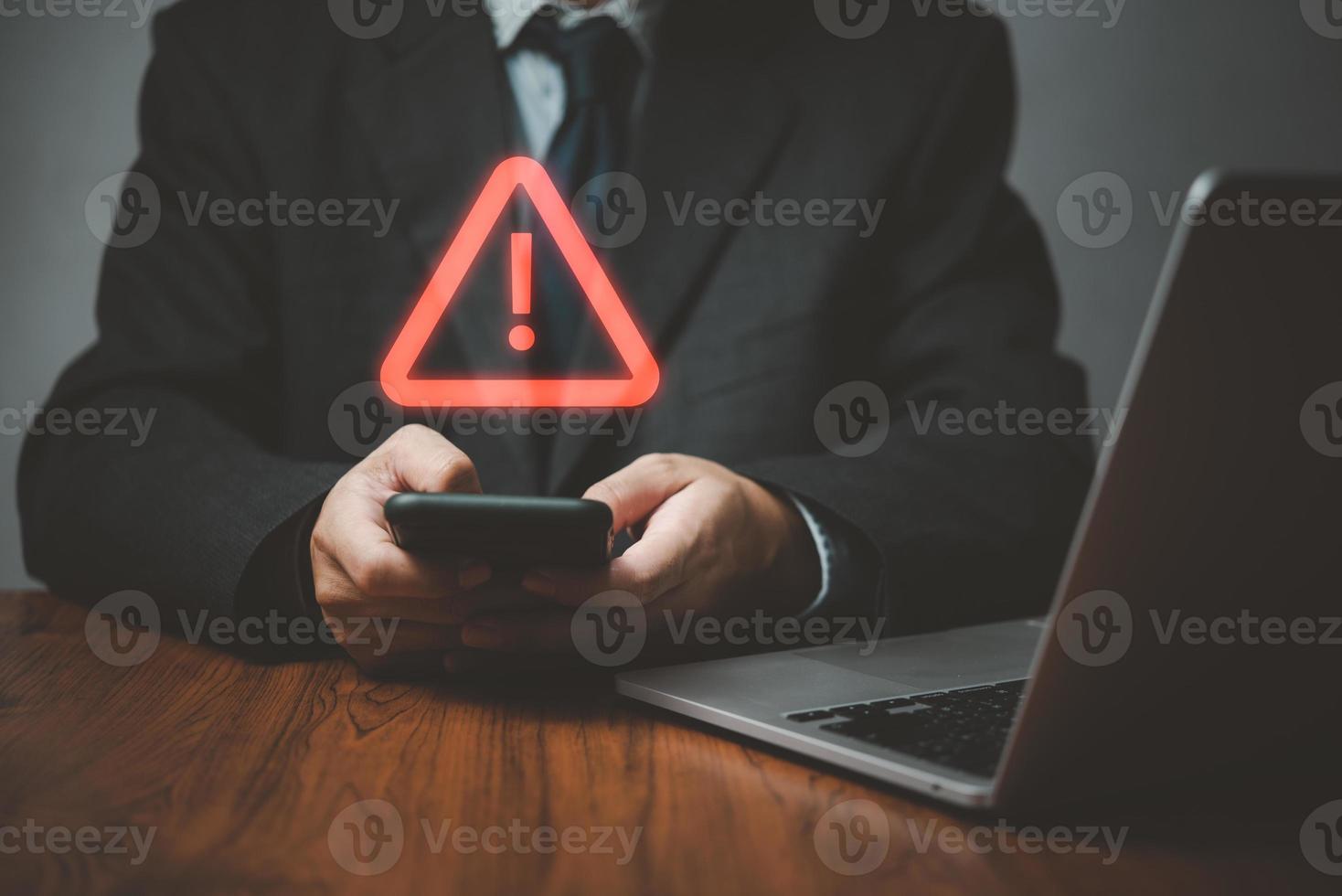 programador de negocios, desarrollador que usa un teléfono inteligente con un signo de advertencia de precaución triangular para el error de notificación y el concepto de mantenimiento. foto