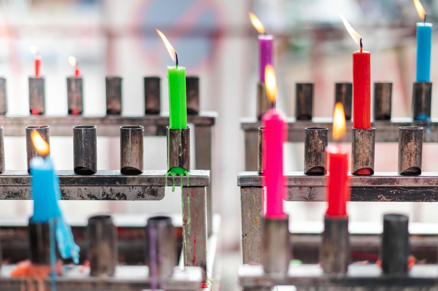 Bunch of prayers candle flames glowing in the Buddhist temple. Symbol of the spiritual atmosphere. photo