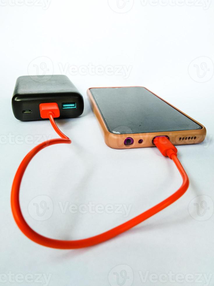 cellphone being charged using a power bank with isolated white background photo