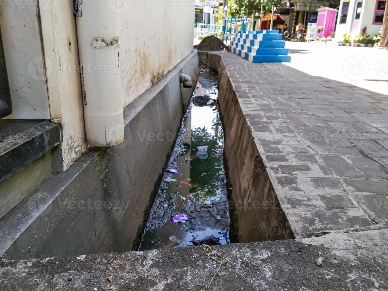 a water ditch in a housing estate that still has trash in it photo