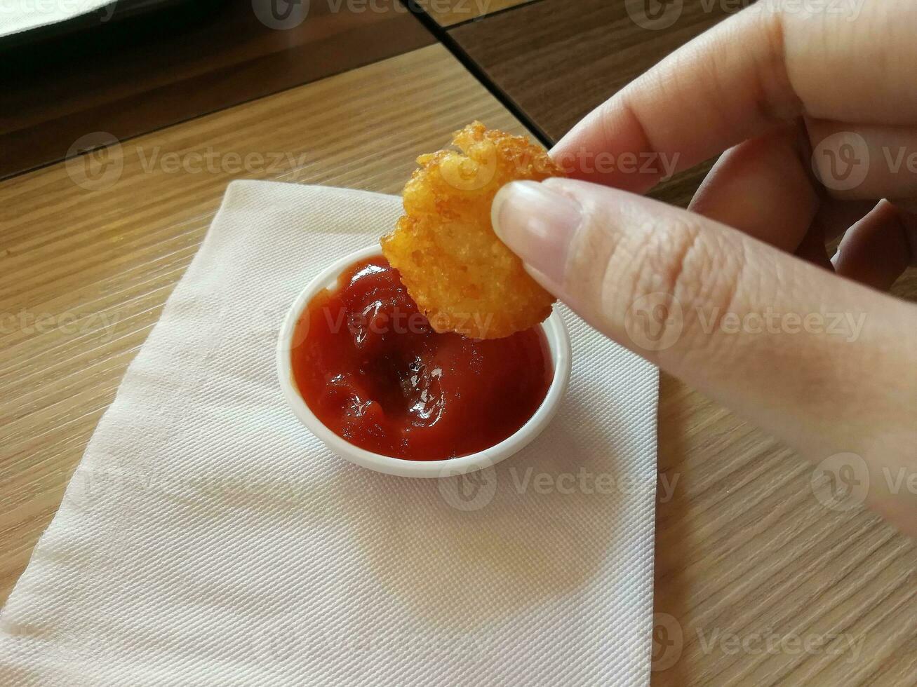 Hash Brown were picked and dipped in tomato sauce. photo