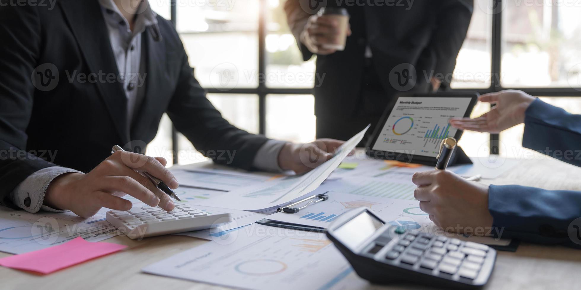 Business People Meeting using laptop computer,calculator,notebook,stock market chart paper for analysis Plans to improve quality next month. Conference Discussion Corporate Concept photo