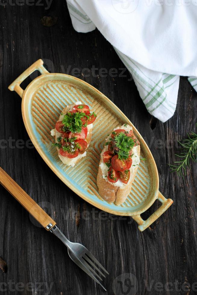 bruschetta de tomate ricotta con tomates cherry, aceite de oliva, romero foto