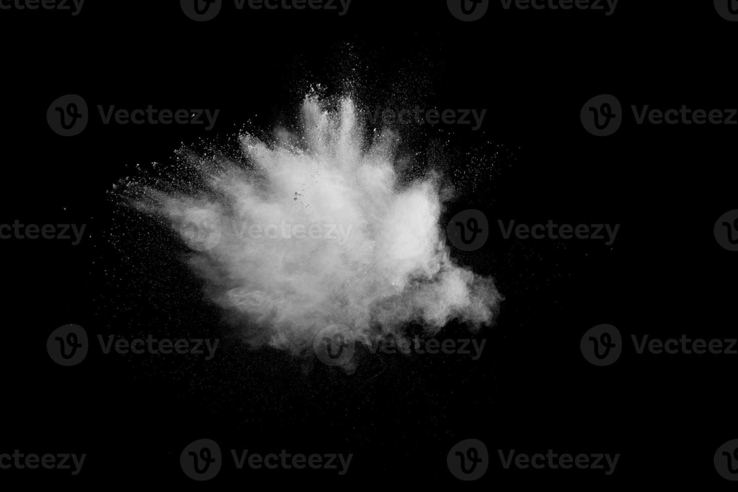 Bizarre forms of of white powder explosion cloud against dark background.Launched white dust splash on black background. photo
