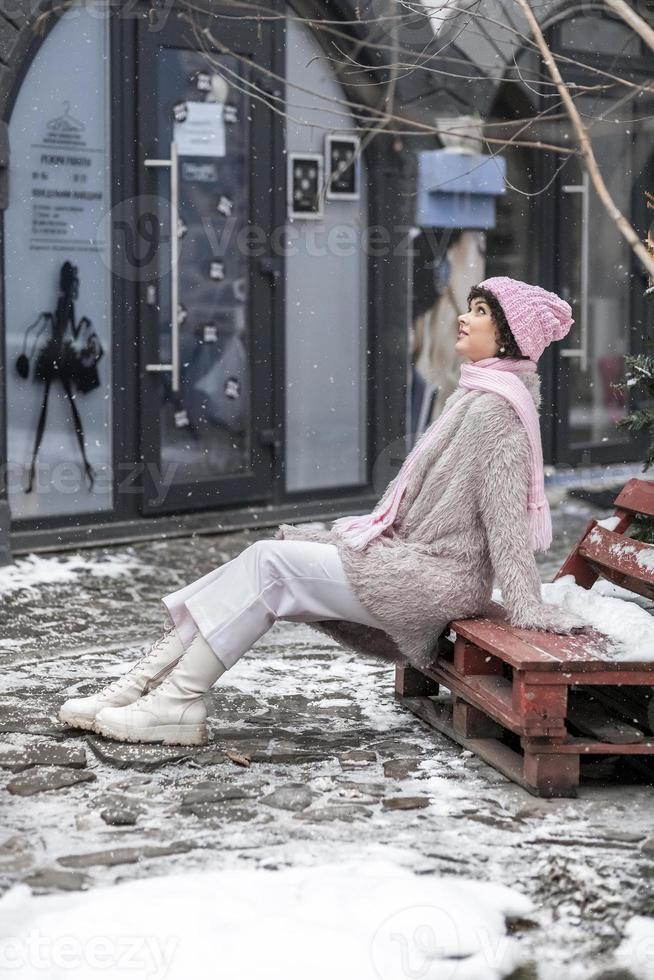 retrato de una mujer joven sonriente y elegante con ropa de abrigo de color  pastel al aire libre en la ciudad en invierno. nevadas, clima frío 17188104  Foto de stock en Vecteezy