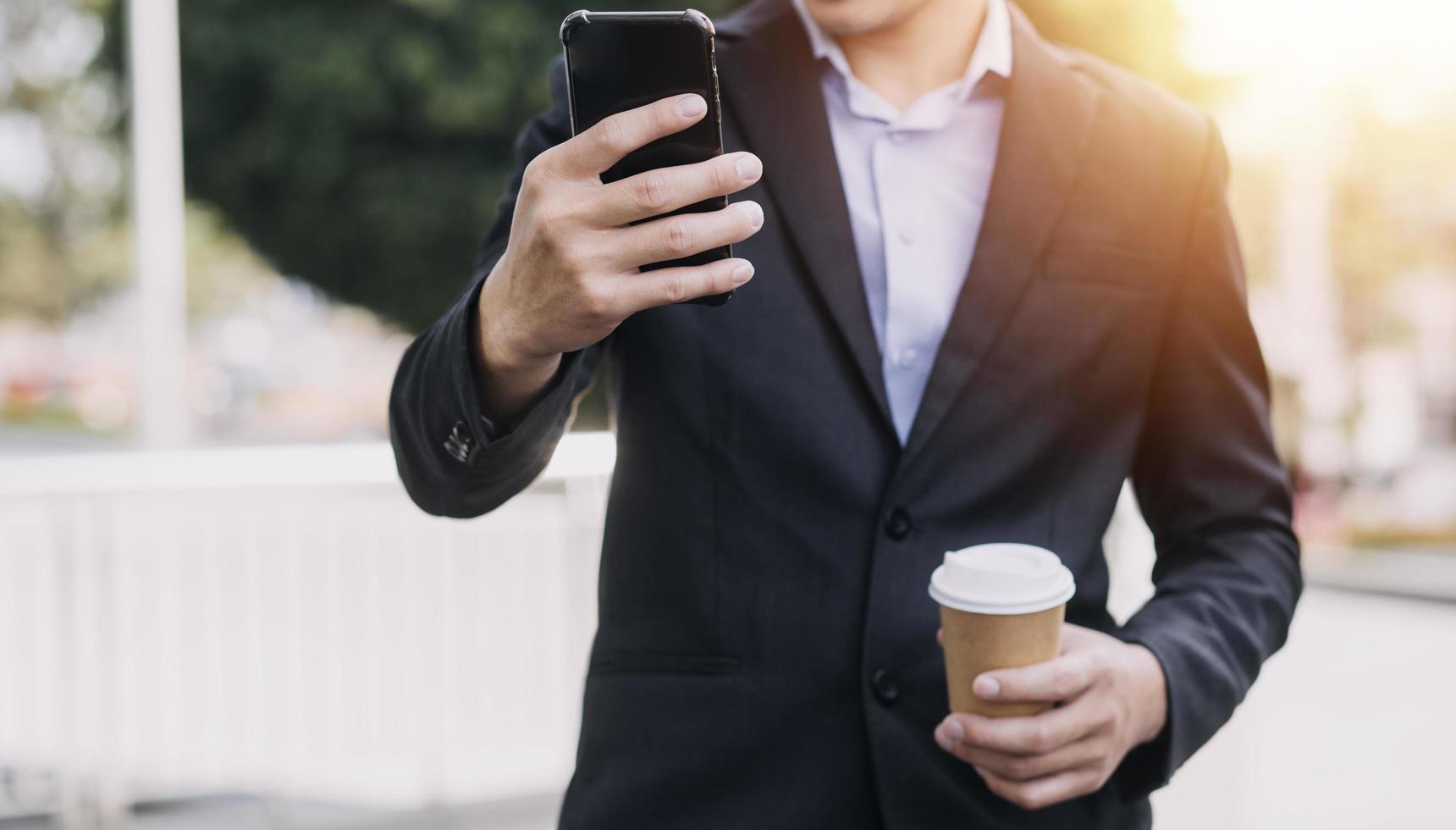 hombre de negocios asiático y mujer hermosa joven que trabajan en una tableta digital de pie fuera del edificio de oficinas. foto