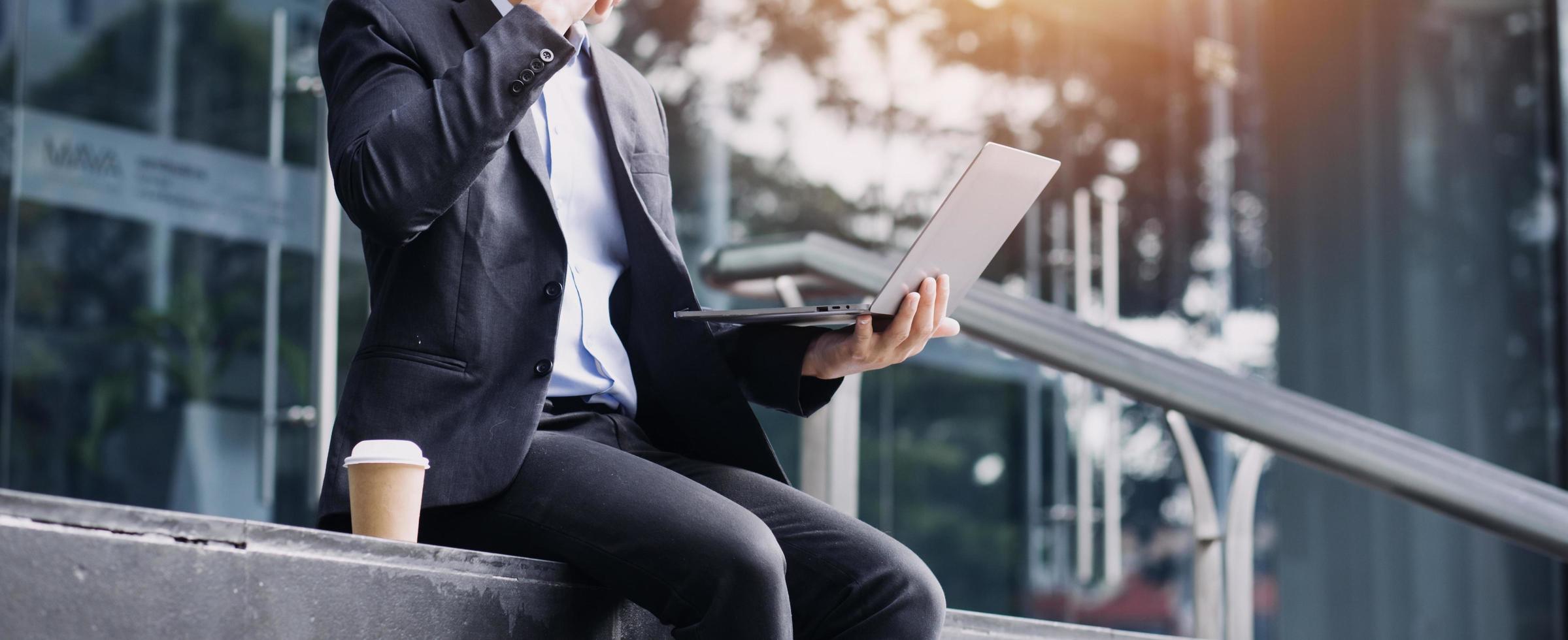 Asian business man and young beautiful woman working on digital tablet computer standing outside office building. photo