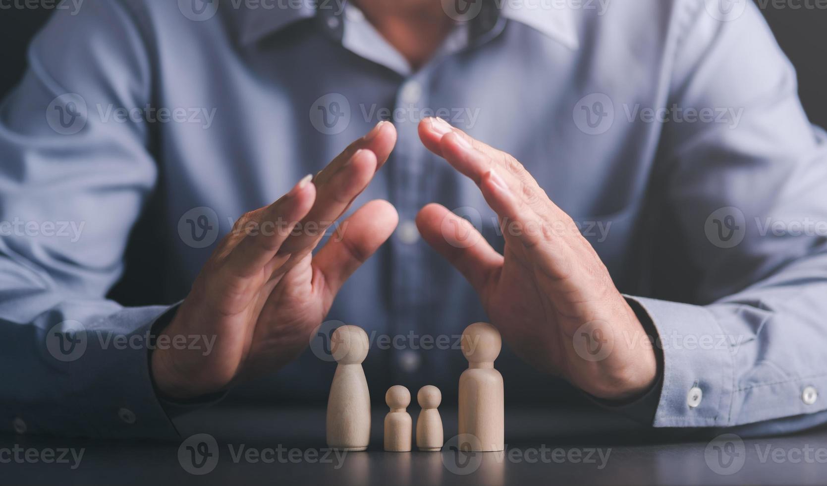 wooden dolls and male hands,Represents the protection and protection of safety,concept of insurance management planning To ensure both health and financial safety,Property and Family Risk Reduction photo