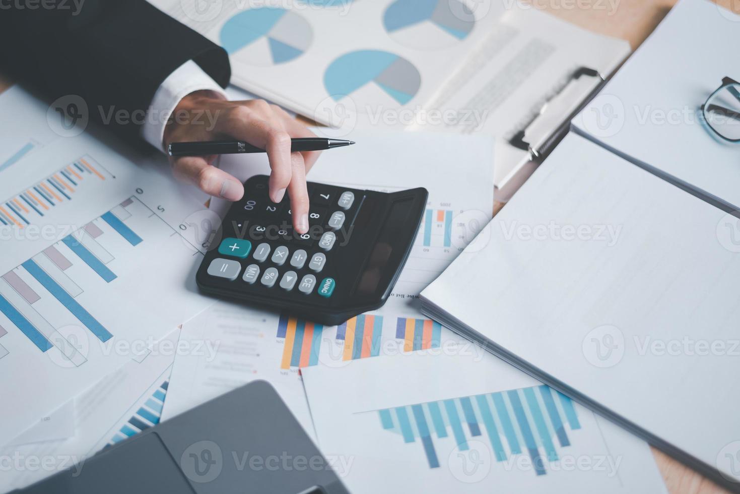 Business people use calculator to calculate documents, profit and loss statement review concept of company performance, effective tax deduction planning for individuals and companies paying tax rates photo