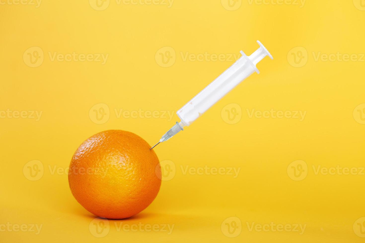 orange fruit with syringe extracting liquid with vitamin C. natural anti aging cosmetics concept photo