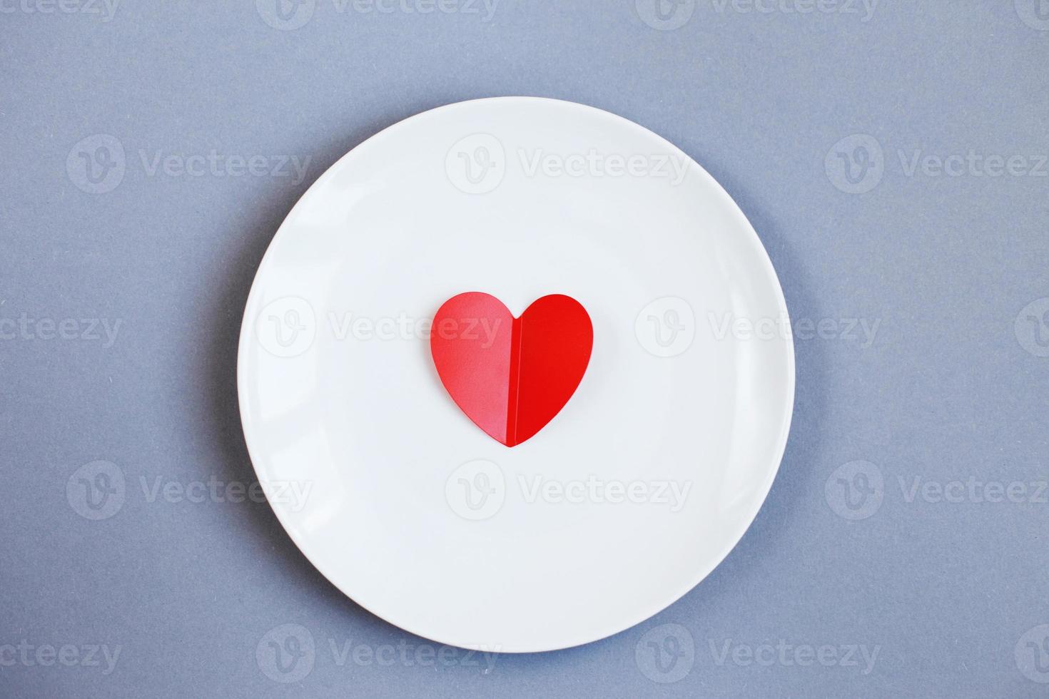 Red Heart on a white plate on grey background photo