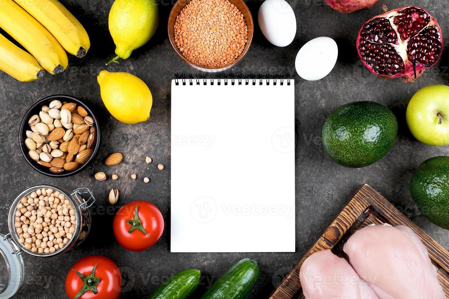 Keto diet food concept. Meat, raw vegetables, nuts and fruits on slate table background. Top view, copy space. Mockup concept with notebook. photo