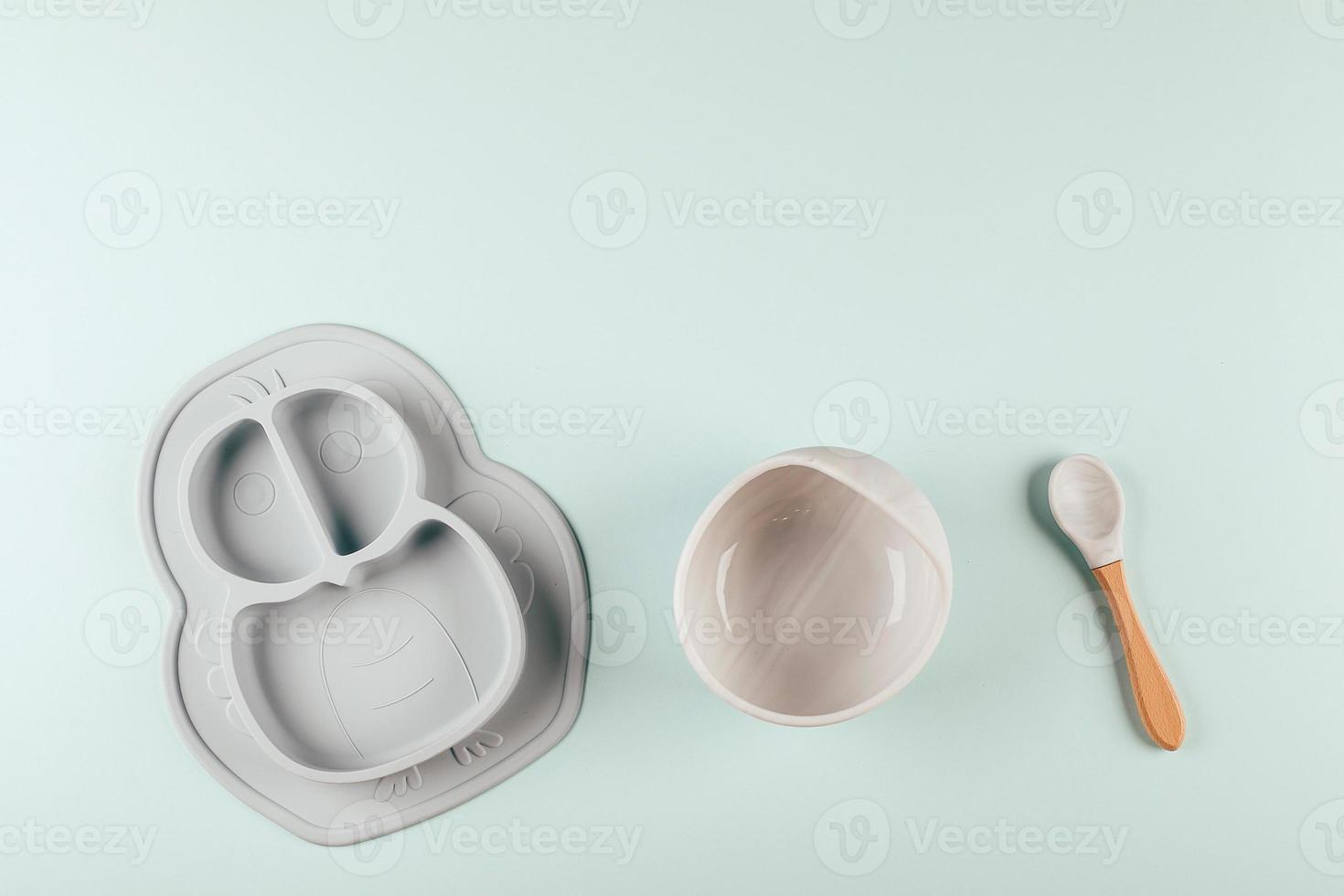 Grey silicone dishware on background. Serving baby, first feeding concept. Flat lay, copy space photo