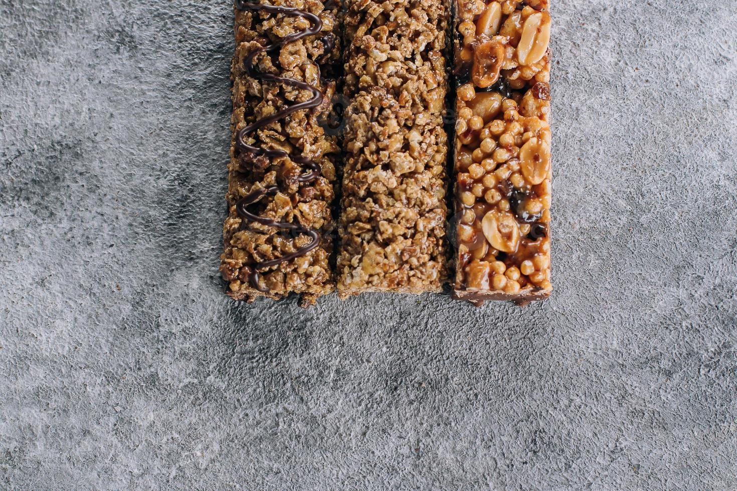 Granola bar. Healthy snack. Cereal granola bar with nuts, chocolate on concrete table background. Copy space photo