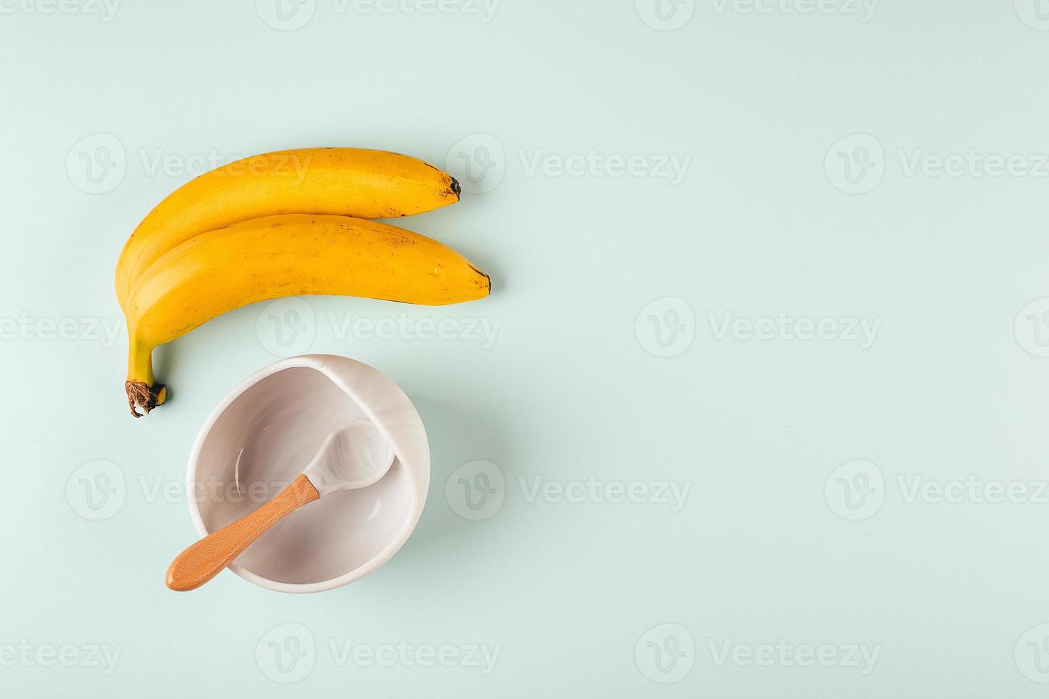 Grey silicone dishware and bananas on background. Serving baby, first feeding concept. Flat lay photo