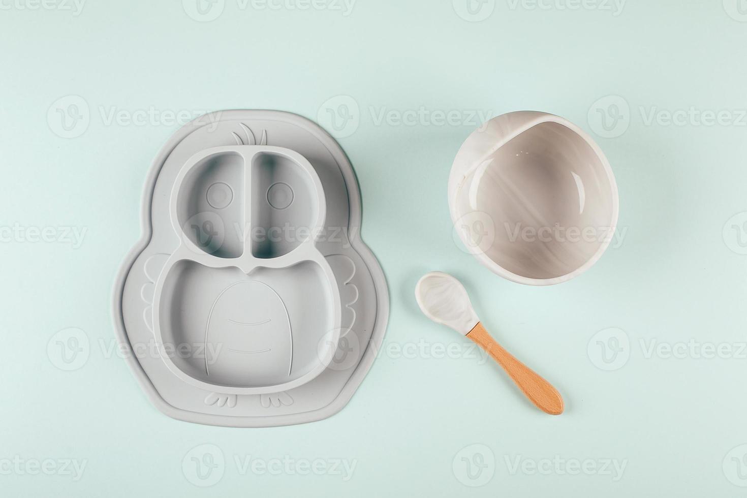 Grey silicone dishware on background. Serving baby, first feeding concept. Flat lay, copy space photo