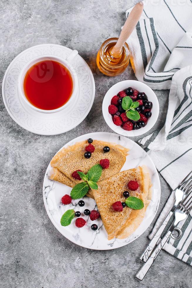 Delicious Crepes Breakfast. Orthodox holiday Maslenitsa. Pancakes with berry black currant raspberry photo