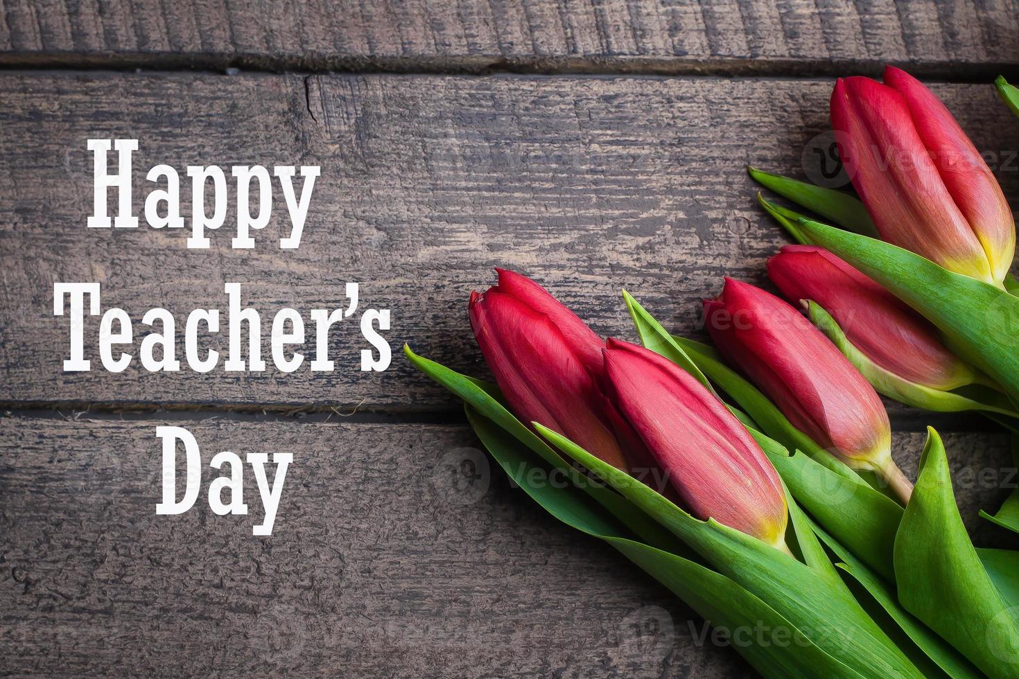 Happy Teacher's Day Card Concept. Spring tulips flowers on a old wooden background. Top view, flat lay photo