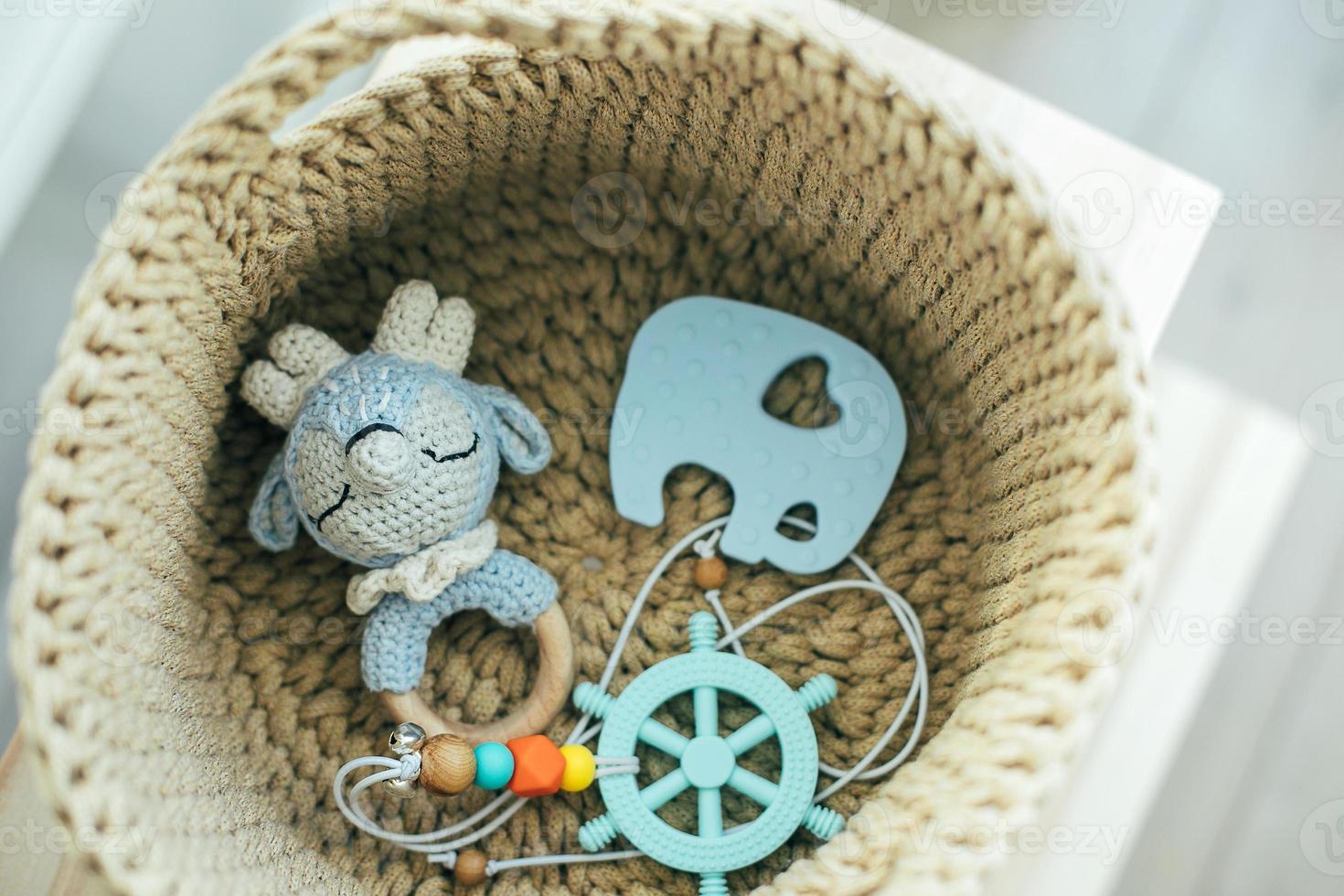 Baby stuff and accessories in knitted basket. Eco friendly, zero waste concept. photo