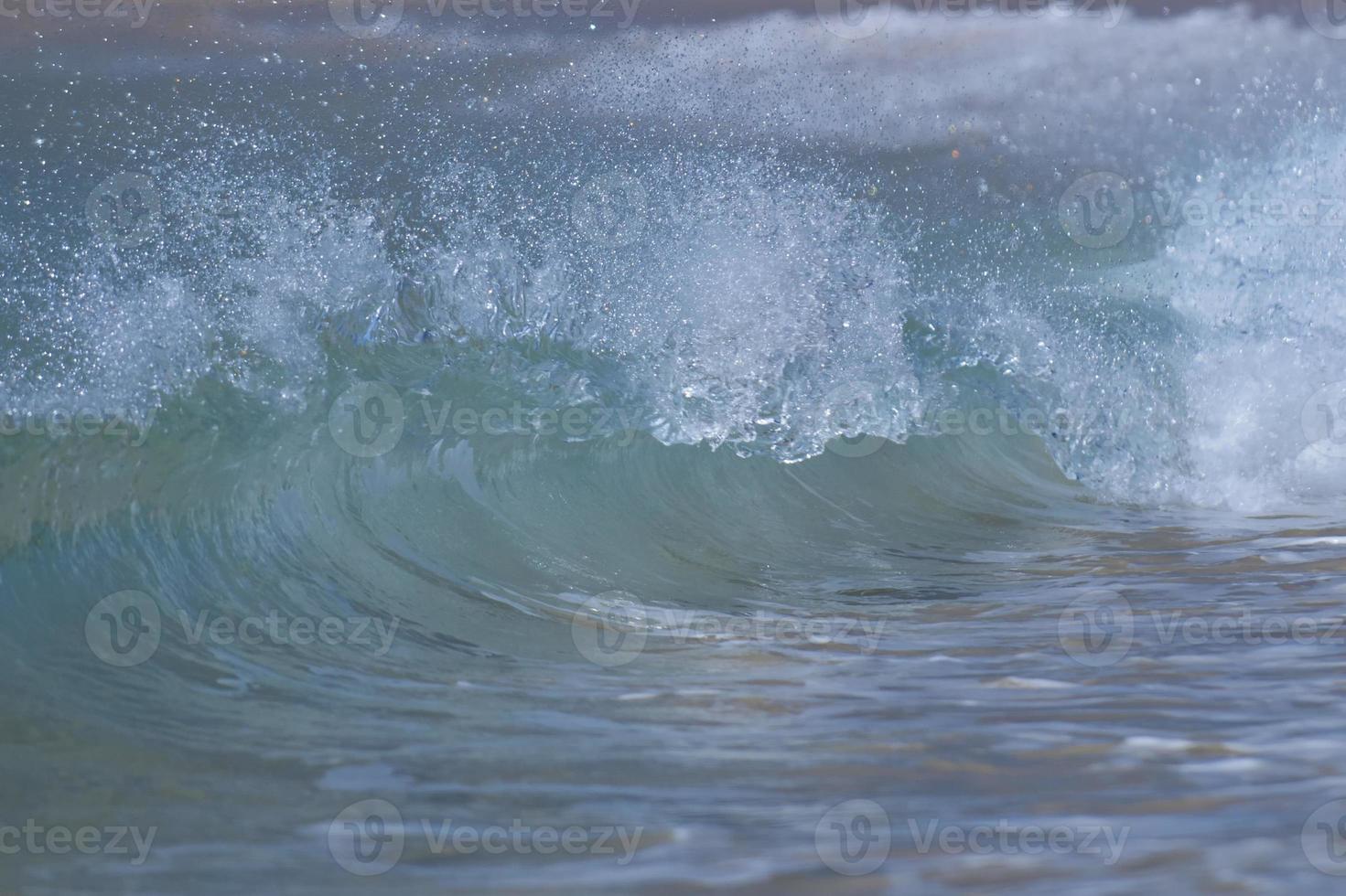 A wave smashing on the sand shore photo