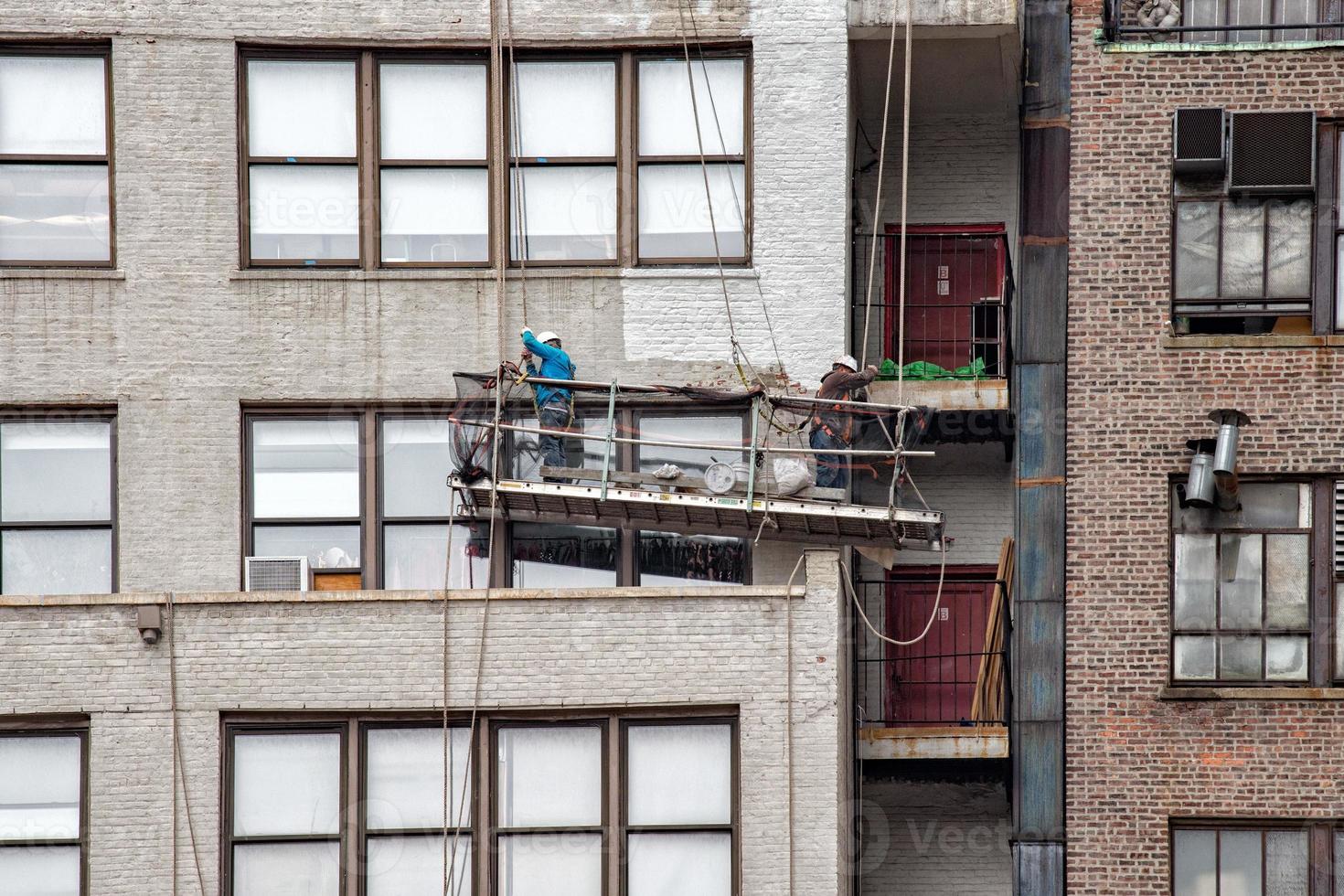 workers restoring building in new york city photo