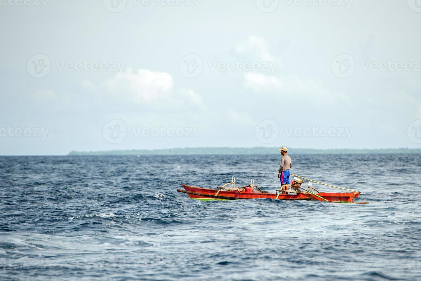 BUNAKEN, INDONESIA - APRIL, 5 2014 - fishing boat returning to fisherman village photo
