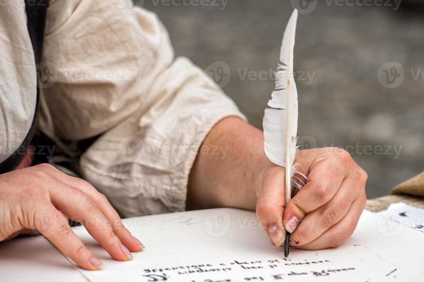 hands writing a letter with a plume photo