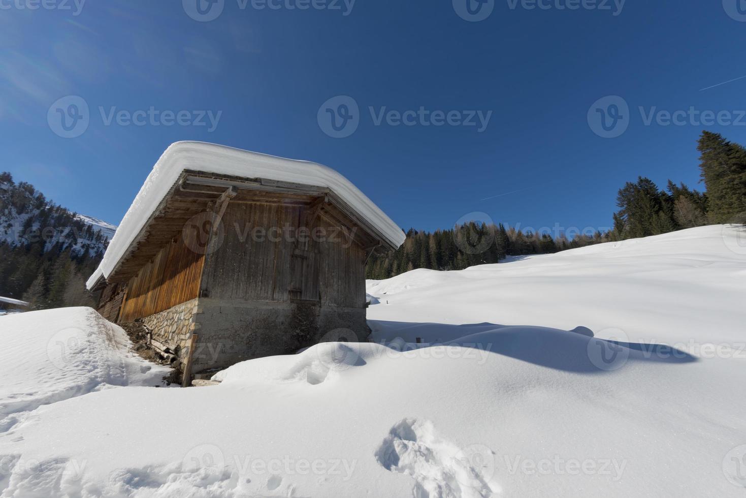 antigua cabaña de madera en el fondo de la nieve blanda foto