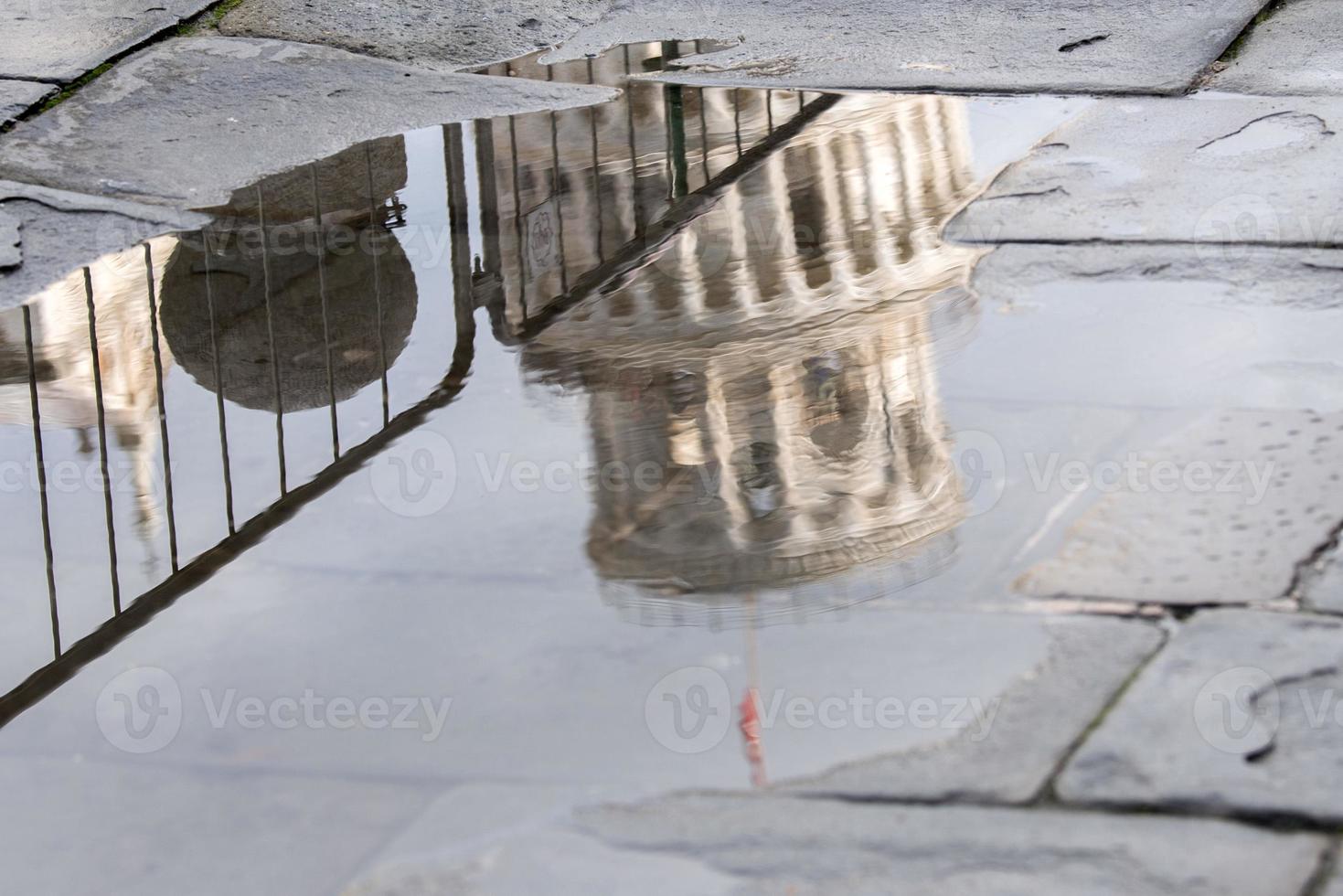 pisa dome and leaning tower close up detail view reflection in a puddle photo