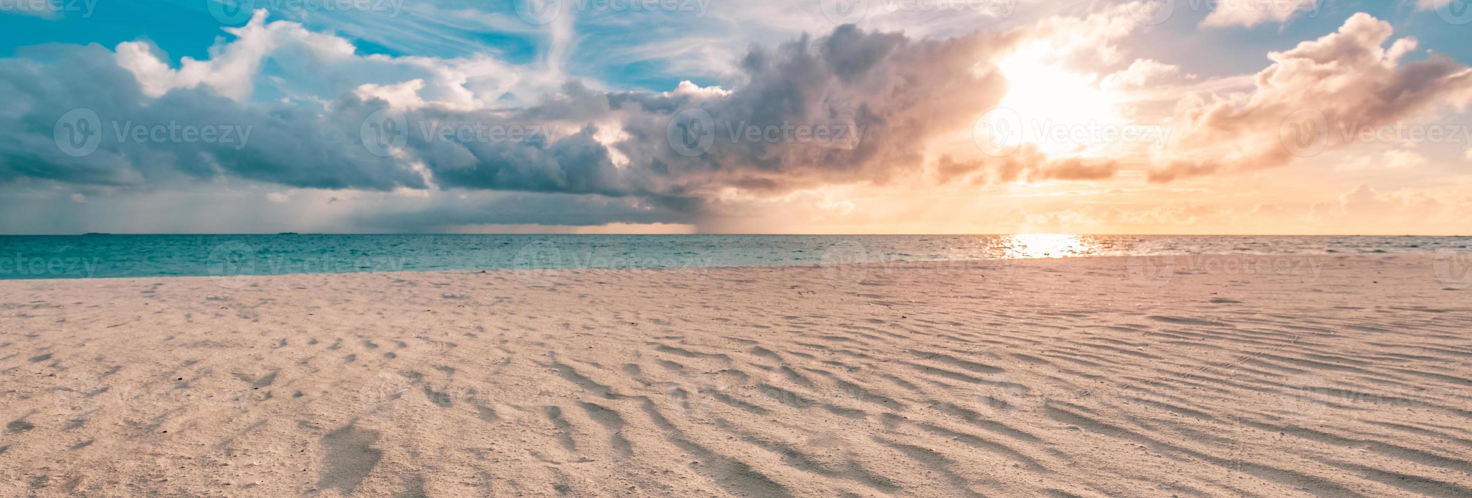 Closeup of sand on beach and blue summer sky. Panoramic beach landscape. Empty tropical beach and seascape. Orange and golden sunset sky, soft sand, calmness, tranquil relaxing sunlight, summer mood photo