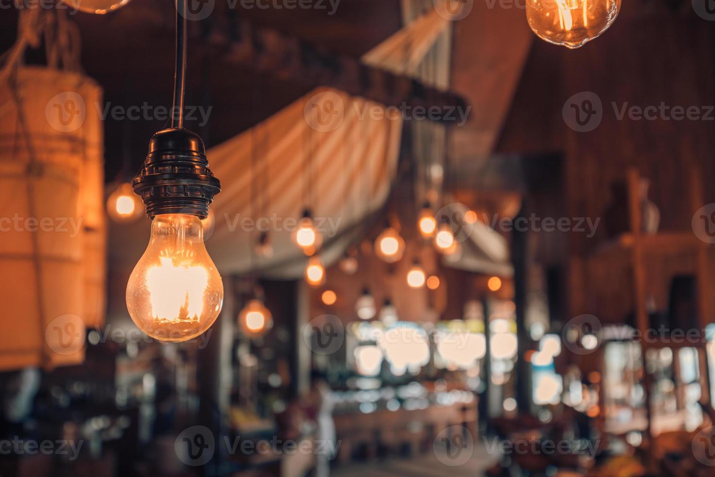 lámpara vintage decorativa en el restaurante, luz de bombilla cálida. luz lámpara electricidad colgando decorar hotel o interior del hogar foto