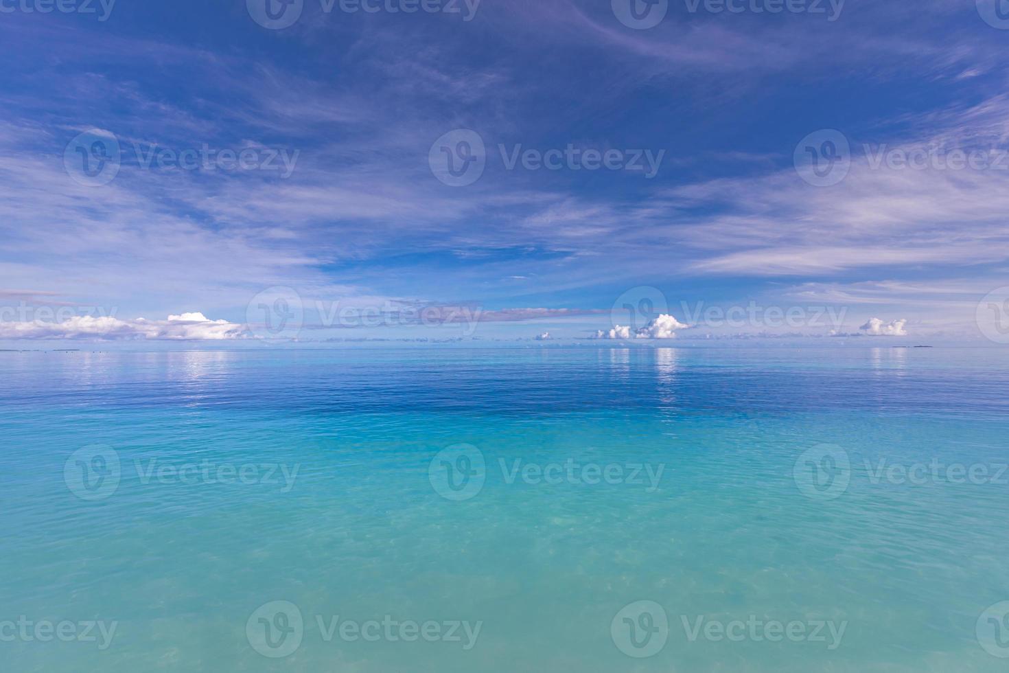 Blue sky over sea or ocean water surface. Idyllic sea and sky template. Tropical beach landscape and seascape, inspirational, tranquil, and relaxing sea view. Horizon, clouds and soft waves photo