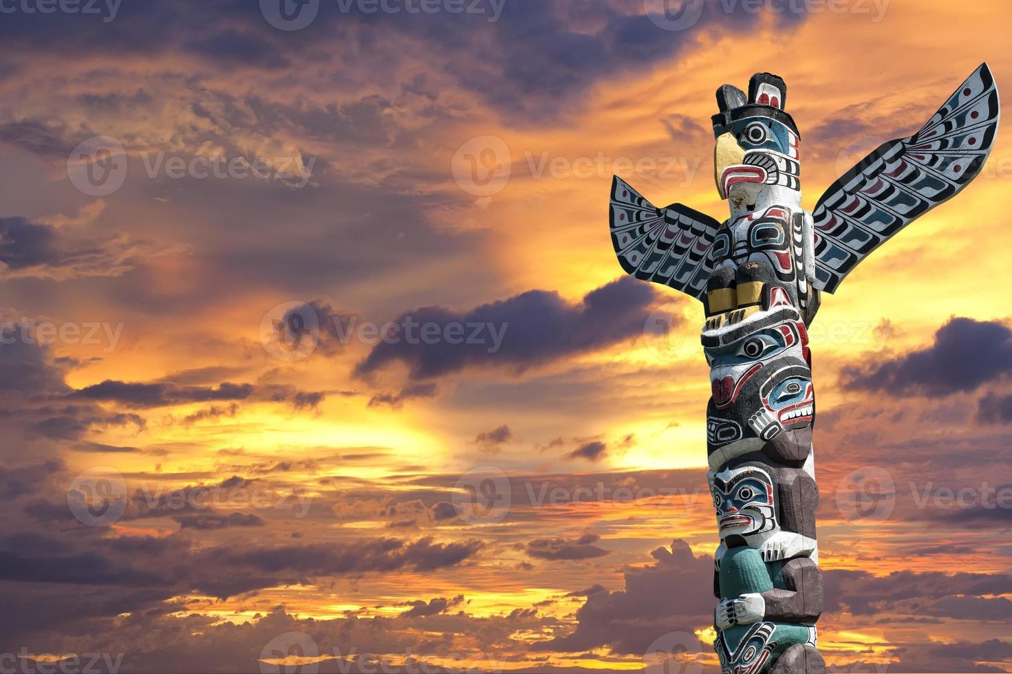 A totem wood pole in the gold cloudy background photo