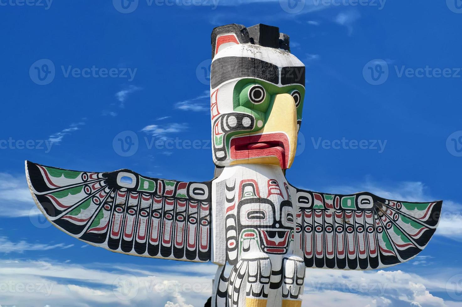 A totem wood pole in the blue cloudy background photo