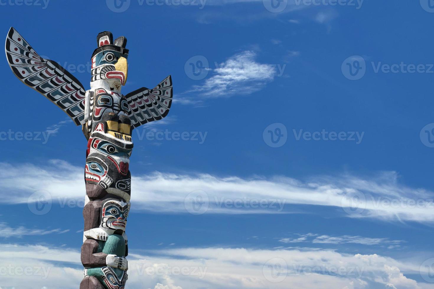 Totem wood pole in the blue cloudy background photo