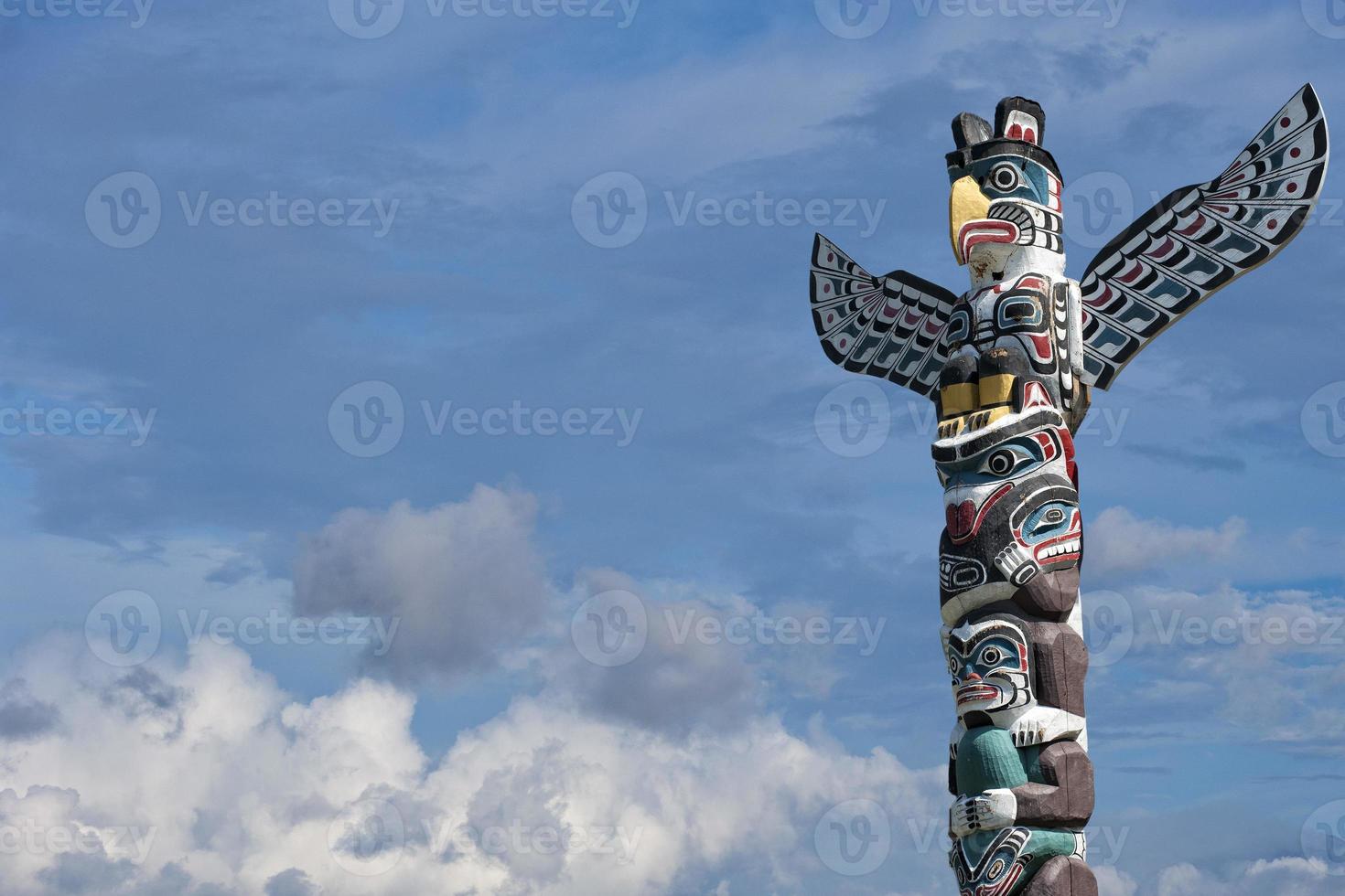 poste de madera totem en el fondo azul nublado foto