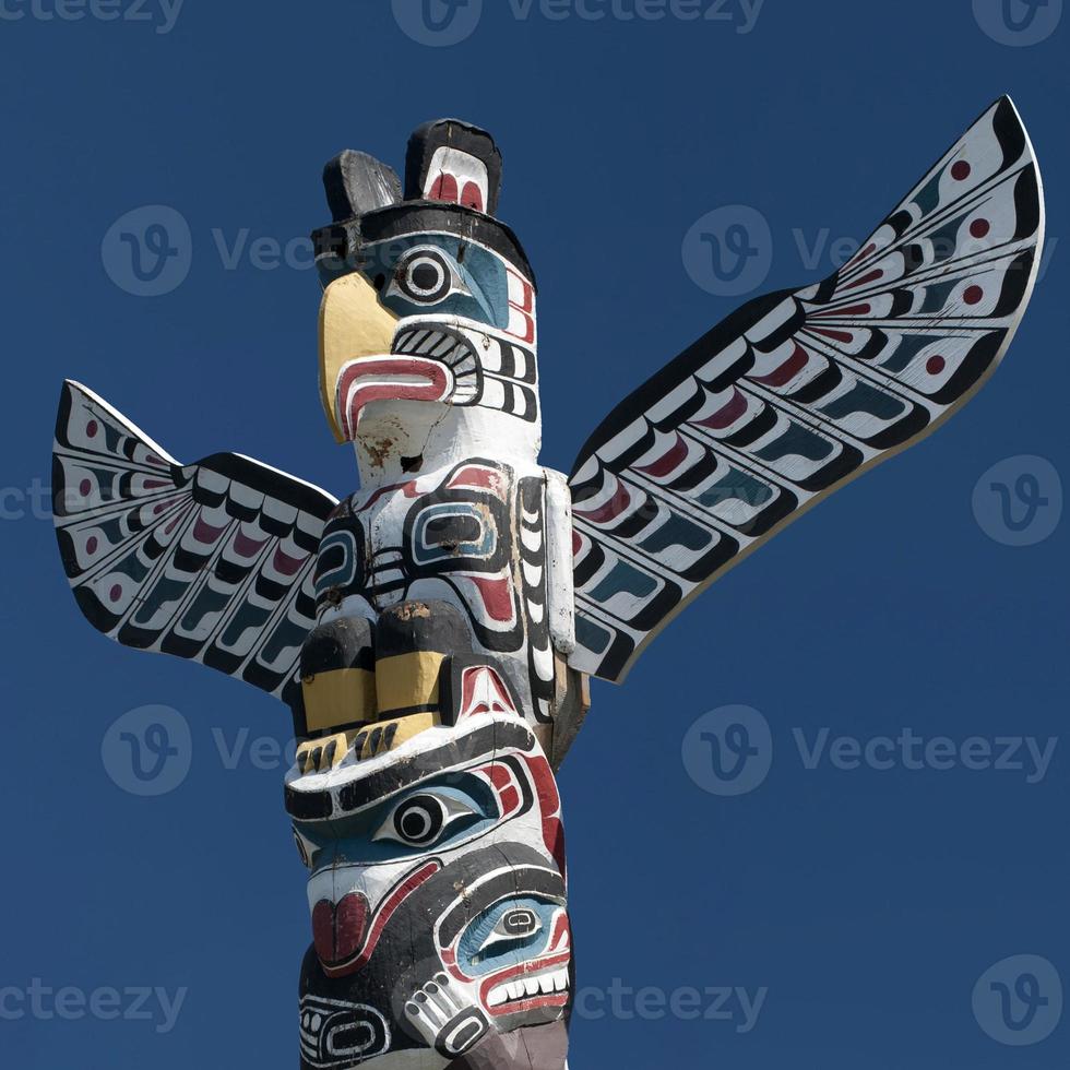 A totem wood pole in the blue cloudy background photo