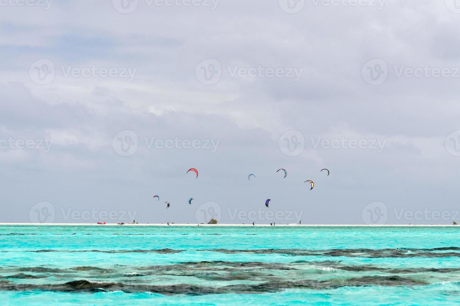 surfistas de cometas en la playa polinesia tropical foto