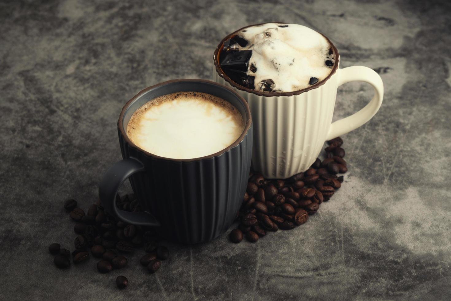 Hot latte and iced latte with coffee beans on concrete background. photo