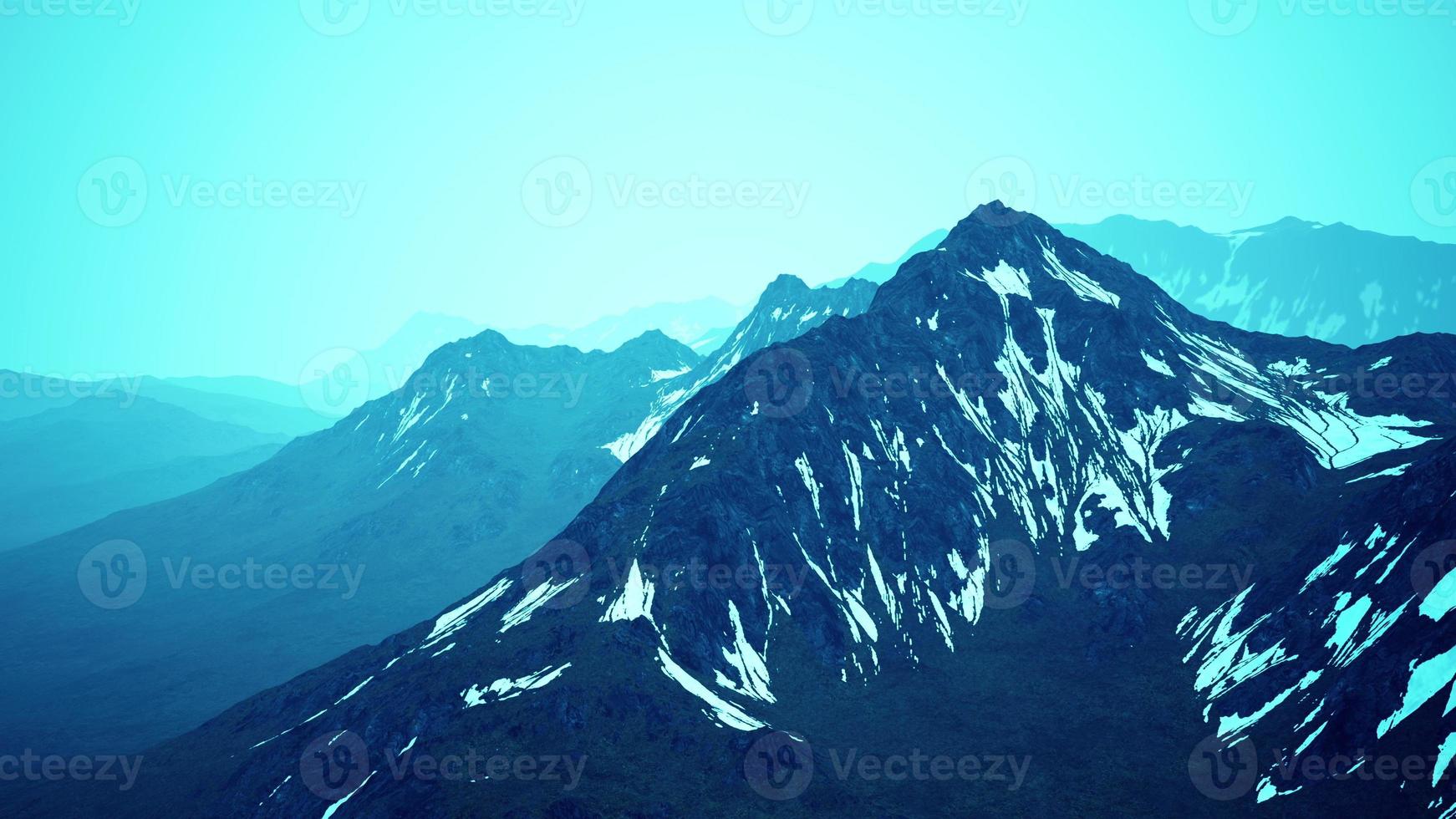 Awesome top view through clouds to high snowy mountains photo