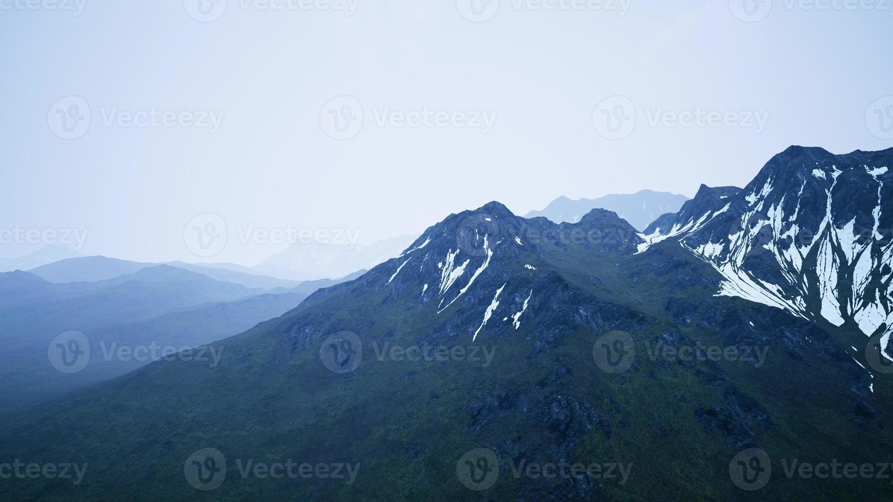 impresionante vista superior a través de las nubes a altas montañas nevadas foto