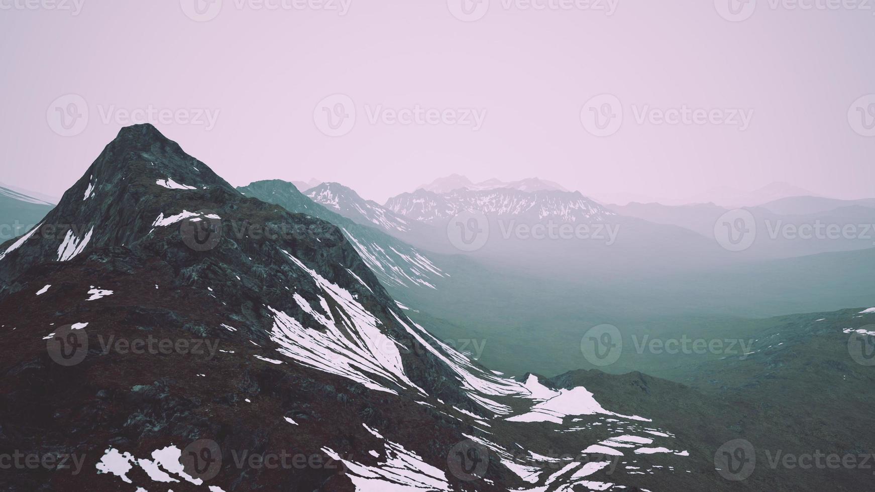 impresionante vista superior a través de las nubes a altas montañas nevadas foto