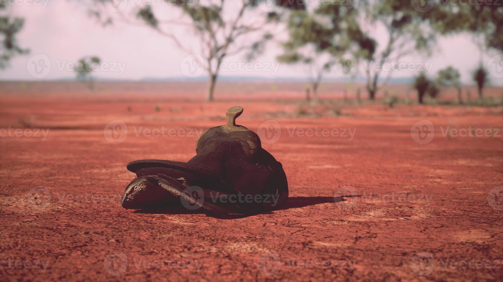 Old decorated mexican saddle lying on sand photo
