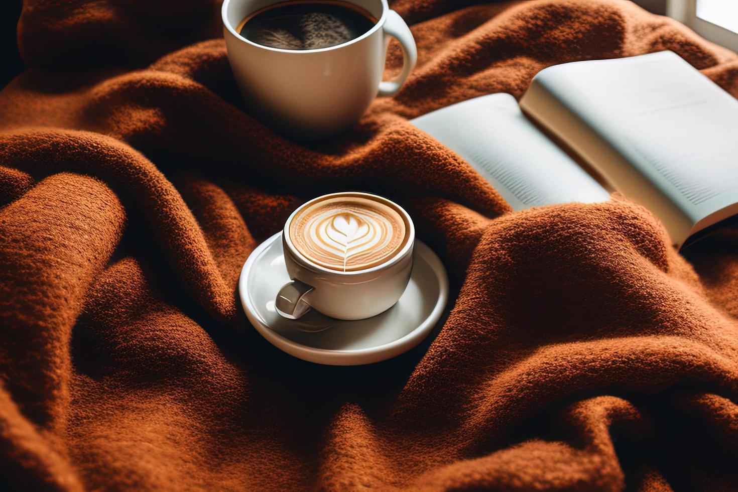 a book sitting on top of a bed next to a cup of coffee photo