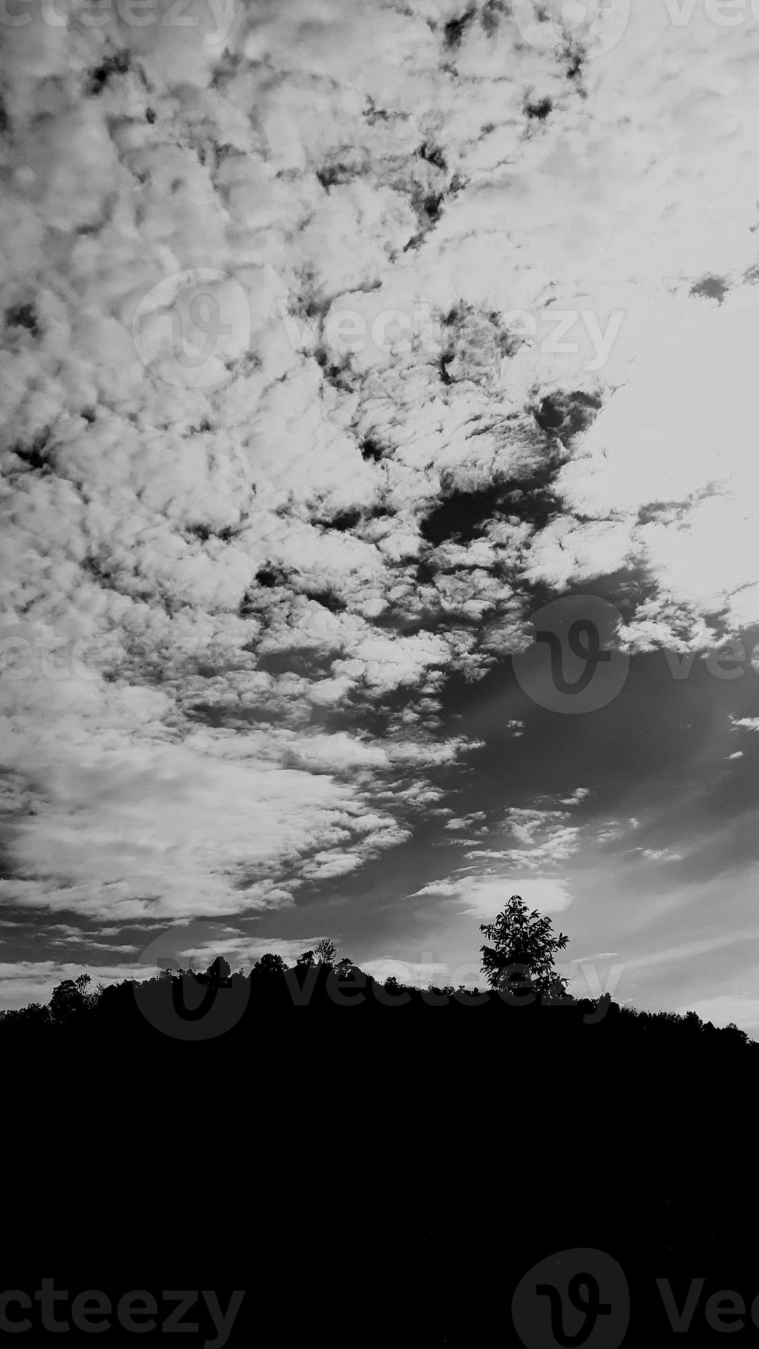 blackwhite picture vertically, dark sky white cloud above top view