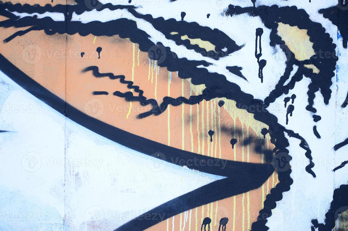 Close-up fragment of a graffiti drawing applied to the wall by aerosol paint. Background image of a modern composition of lines and colored areas. Street art concept photo