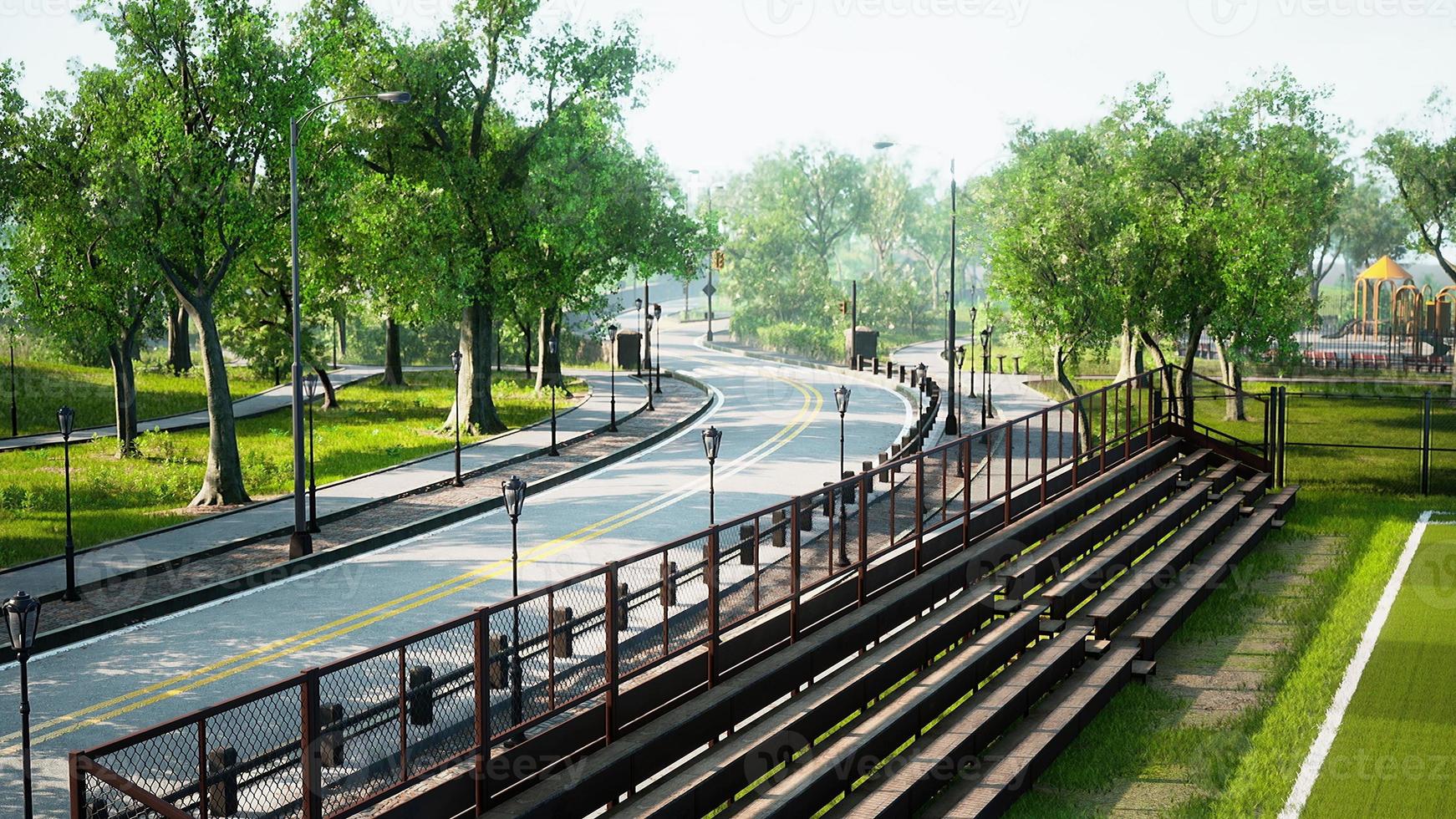 Asphalt road and green trees in park photo